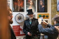 a man in a top hat is taking a picture of a man in a top hat