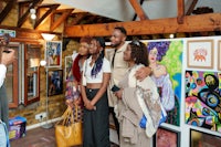 a group of people standing in front of art