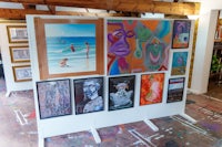 a group of paintings on display in a room