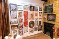 a room with many framed pictures and a fireplace