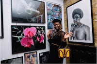 a woman is posing in front of a bunch of framed pictures